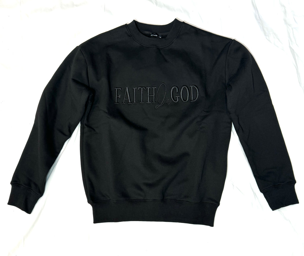 A person wearing a black sweatshirt with 'FAITH IN GOD' embroidered on the chest.