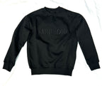 A person wearing a black sweatshirt with 'FAITH IN GOD' embroidered on the chest.